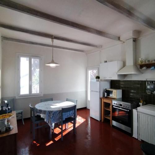 une cuisine avec une table et une salle à manger dans l'établissement Le bastidon du grand chene, à Pontevès