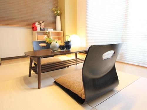 a living room with a table and a chair at Alphabed広島平和大通り in Hiroshima