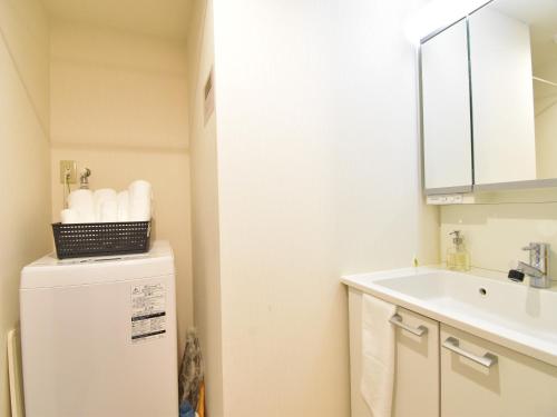 a small kitchen with a sink and a refrigerator at Alphabed広島平和大通り in Hiroshima