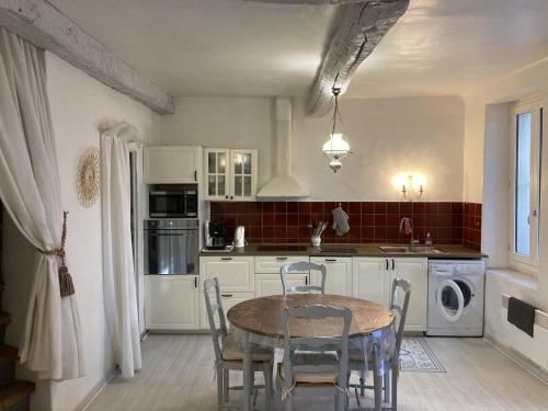 una cucina con un tavolo e delle sedie di Le gite petit-conil a Correns