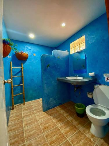 a blue bathroom with a toilet and a sink at Pandora Café in Chaweng