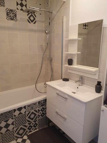 une salle de bain avec un lavabo blanc et une douche dans l'établissement Duplex appartement 4 chambres120m2, à Grande-Synthe