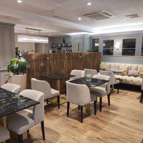 a waiting room with tables and chairs and a couch at Hotel Avenue Louise Brussels Trademark Collection by Wyndham in Brussels