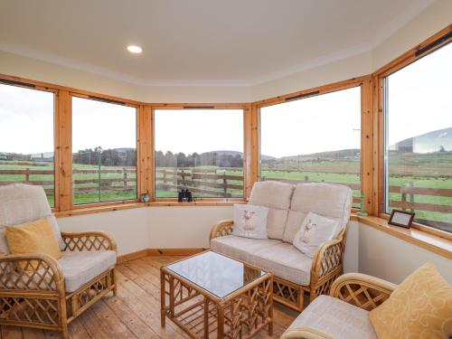 a screened in porch with two chairs and a table at Bogairn in Carron
