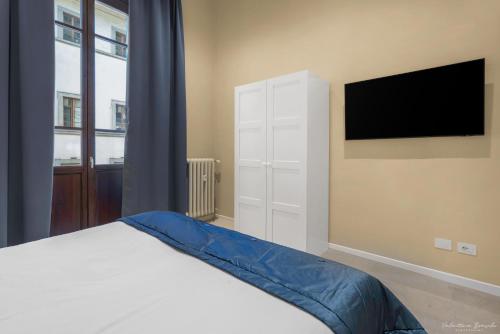 a bedroom with a bed and a flat screen tv at B&B Le Stanze del Duomo in Florence
