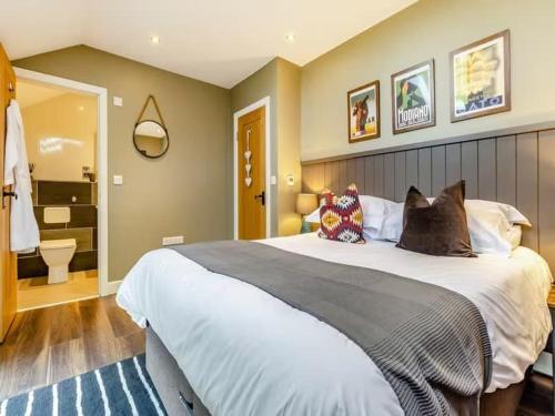 a bedroom with a large bed and a bathroom at Beautiful Stone Barn with Hot Tub on a Quiet Farm in Eckington