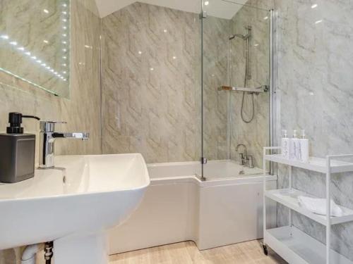 a bathroom with a tub and a sink and a shower at Beautiful Stone Barn with Hot Tub on a Quiet Farm in Eckington