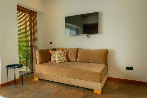 a couch in a living room with a tv on the wall at Nakas Hotel in Fethiye