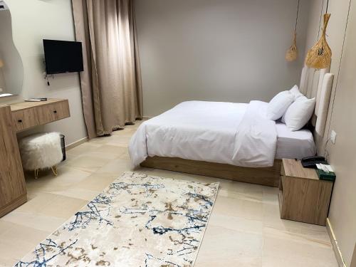 a bedroom with a bed and a television and a rug at Pyramids Height Hotel & Pyramids Master Scene Rooftop in Cairo