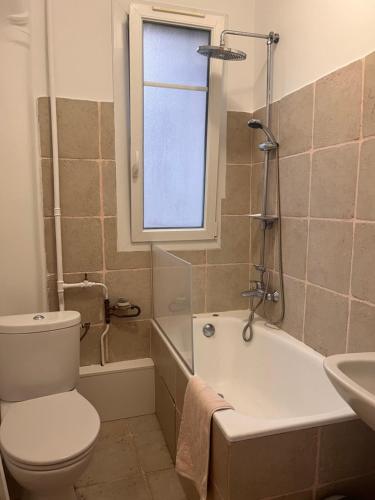 une salle de bain avec toilettes, baignoire et lavabo dans l'établissement Appartement de charme F2, Porte St Cloud, à Boulogne-Billancourt