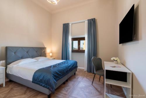 a bedroom with a bed and a desk and a television at B&B Le Stanze del Duomo in Florence