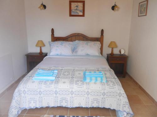 a bedroom with a bed with two towels on it at Windmill Hill in Cercal