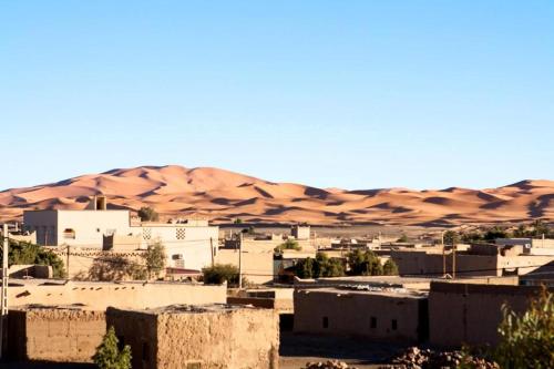 a city in front of a desert with hills and buildings at Chez Kossai Atlas Farm in Chtawna