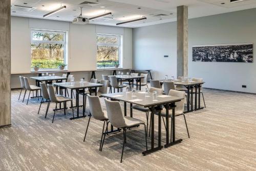 a room with tables and chairs and a white wall at Park Inn by Radisson Vilnius Airport Hotel & Conference Centre in Vilnius