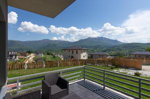a balcony with two chairs and a view of mountains at pazaric residence in Doljani