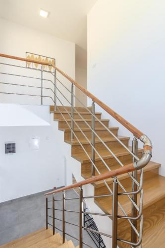 a metal spiral staircase in a house with white walls at pazaric residence in Doljani