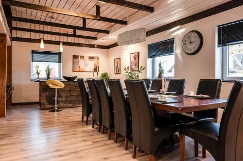 a dining room with a table and chairs and a clock at Unique rustic property in skåne in Linderöd