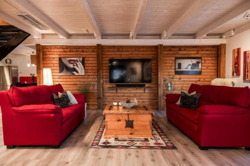 a living room with two red couches and a tv at Unique rustic property in skåne in Linderöd