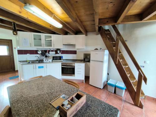 eine Küche mit weißen Schränken und einer Treppe in der Unterkunft The Windhouse in São Bartolomeu