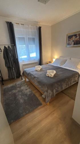a bedroom with a large bed with two towels on it at Holiday House Provance in Brod na Kupi