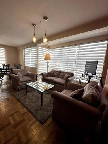 a living room with couches and a coffee table at Departamento soleado y acogedor en el mejor barrio de la ciudad in La Paz
