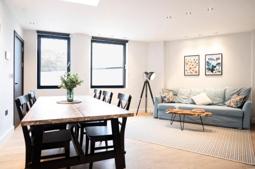 a living room with a table and a couch at Xylo Apartments - Kentish Town in London
