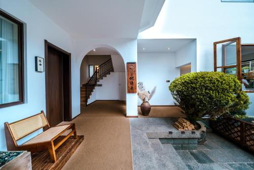 a hallway of a house with a bench and a plant at The Whisperer Guanshan Private Residence Hotel in Dali