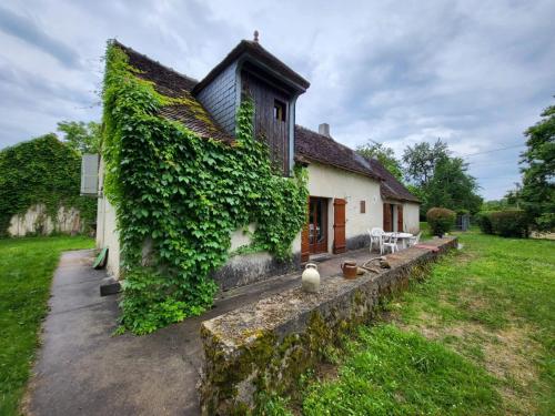 a house with ivy growing on the side of it at Maison de Campagne Les Loges de Brenne in Ardentes