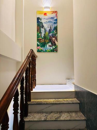 a painting hanging on a wall next to stairs at MOTEL Đồng Khởi in Giồng Tú Ðiền