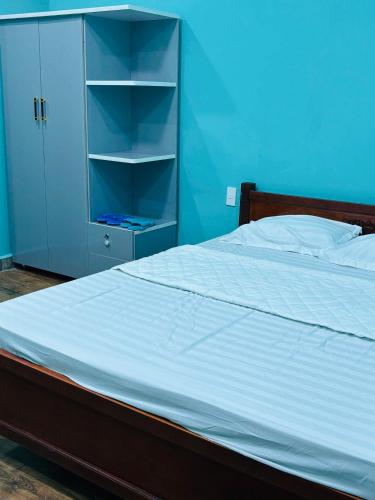 a bedroom with a bed and a blue wall at MOTEL Đồng Khởi in Giồng Tú Ðiền