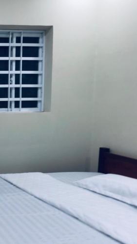 a white bed in a room with a window at MOTEL Đồng Khởi in Giồng Tú Ðiền