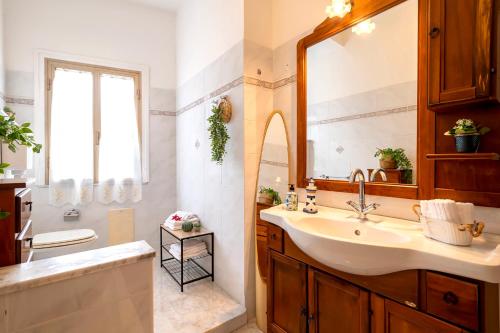 een badkamer met een wastafel en een spiegel bij Villa Le Dune a few steps from the sandy beach of Maria Pia in Alghero