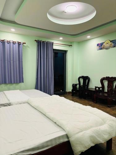a bedroom with two twin beds and a ceiling at MOTEL Đồng Khởi in Giồng Tú Ðiền