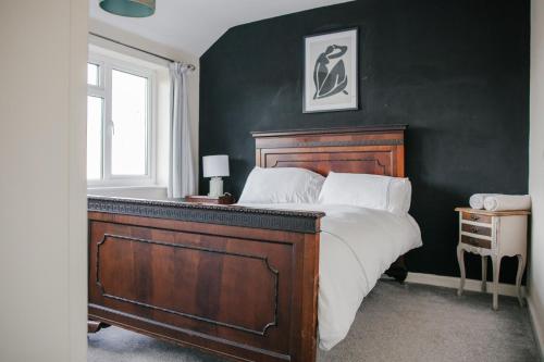 a bedroom with a large bed and a green wall at Entire 3 bedroom house, SALISBURY Cathedral City in Salisbury