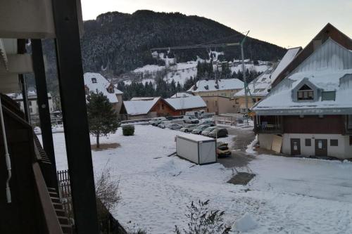 a town with snow covered buildings and a mountain at Large south-facing studio in Saint-Pierre-de-Chartreuse
