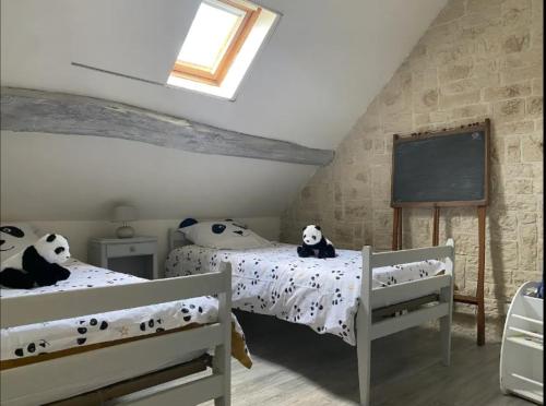 - une chambre avec 2 lits avec des pandas rembourrés dans l'établissement La maison des Hautes Vallees- jardin-piscine Beauval, à Lye