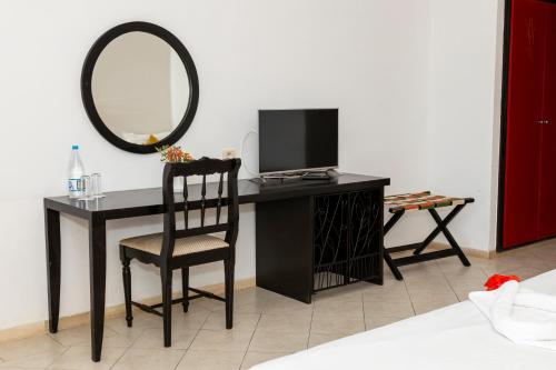a desk with a tv and a mirror and a chair at Le Petit Palais Djerba & Spa in Houmt Souk