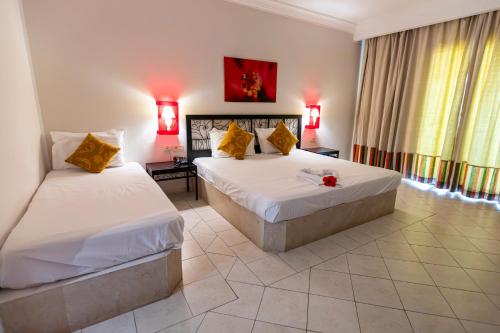 a hotel room with two beds and a couch at Le Petit Palais Djerba & Spa in Houmt Souk