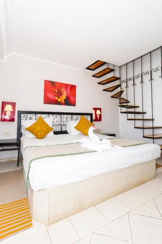 a bedroom with a large bed and a spiral staircase at Le Petit Palais Djerba & Spa in Houmt Souk
