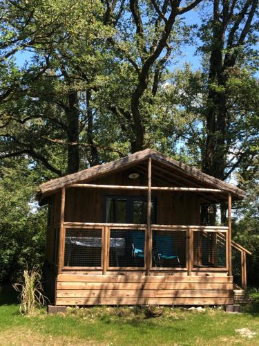 a cabin in the woods with two chairs in it at Les Lodges de Phanou in Prissac