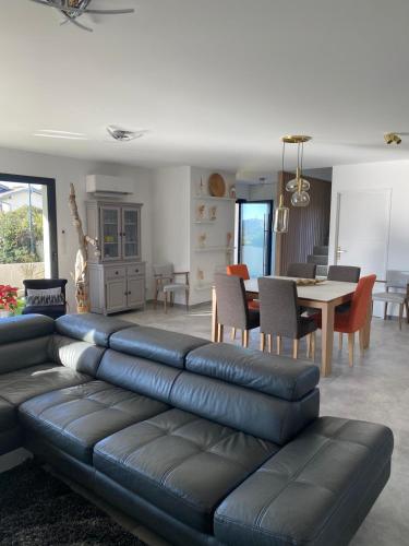 - un salon avec un canapé en cuir et une salle à manger dans l'établissement Villa zen bord de mer, à Sète