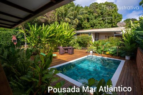 a swimming pool in the middle of a garden at Pousada Mar Atlântico in Fernando de Noronha