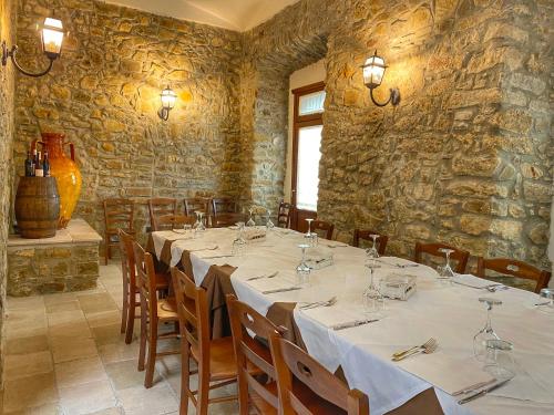 a dining room with a long table in a room with stone walls at Palazzo Iaquinta - Rooms, Restaurant & Wellness in Cicerale