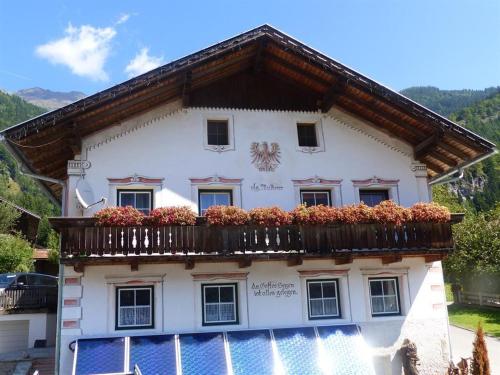 a building with a balcony with flowers on it at Multererhof in Nikolsdorf