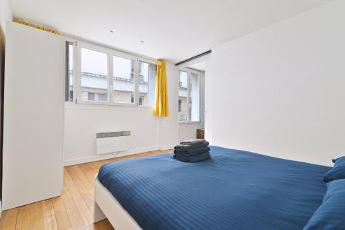 une chambre avec un lit bleu et une fenêtre dans l'établissement Superb Apartment Quartier Republique Free Netflix, à Paris