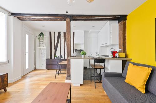 un salon et une cuisine avec un canapé et une table dans l'établissement Superb Apartment Quartier Republique Free Netflix, à Paris