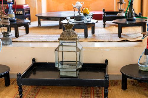 a glass lantern on a table in a room with tables at Le Petit Palais Djerba & Spa in Houmt Souk