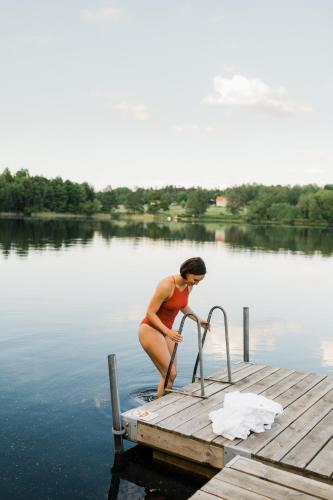a woman standing on a dock in the water at Asa Herrgård in Asa