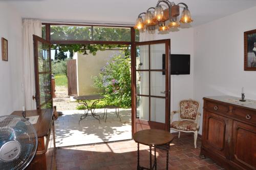 an open door to a patio with a table and chairs at Gîte Du Mas Des Oliviers in Mézoargues