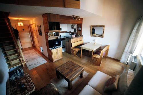 un salon avec une table et une cuisine dans l'établissement Duplex Chalet Edelweiss - La Plagne Montalbert, à Montalbert